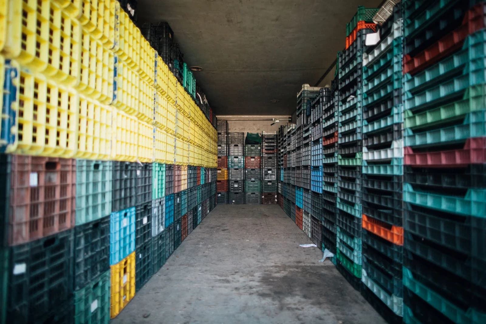 Caisse palette plastique monobloc grise en entrepôt logistique